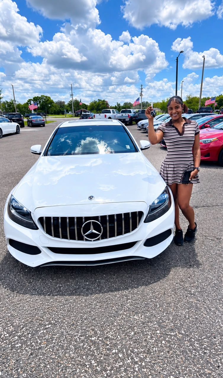 Customer picking up her new vehicle, holding up the keys