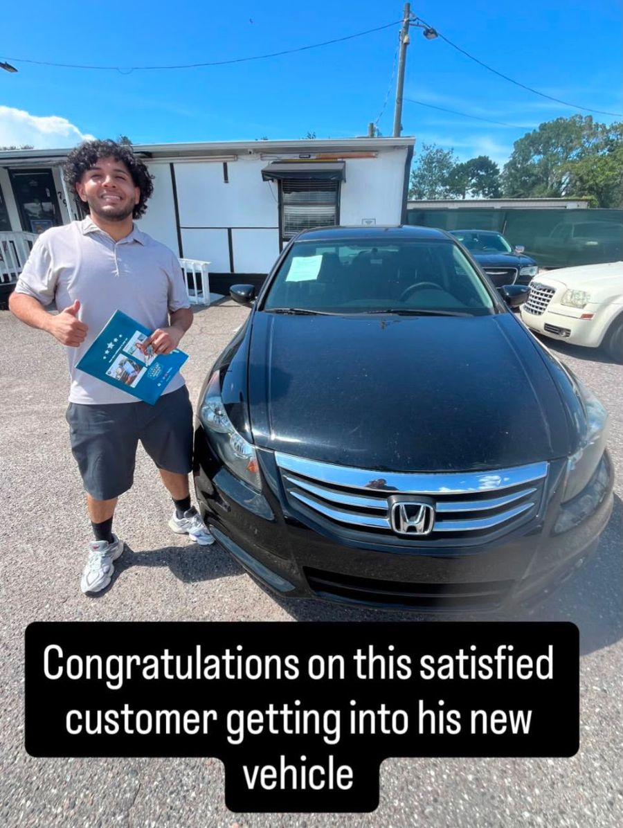 Customer holding paperwork next to his new Honda Accord