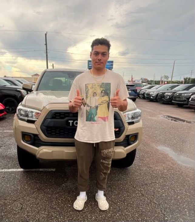 Customer giving a thumbs up next to his new Toyota Tacoma